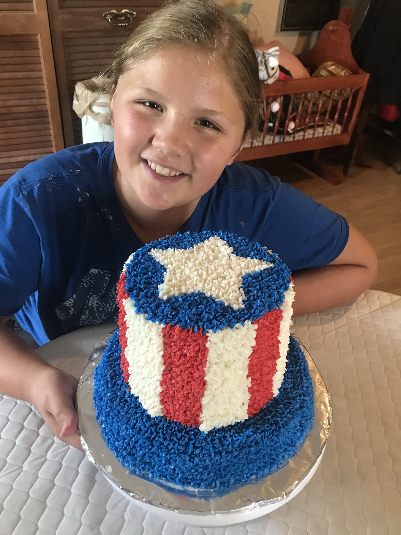 One of the sisters proudly holding a two-tier red, white, and blue celebration cake