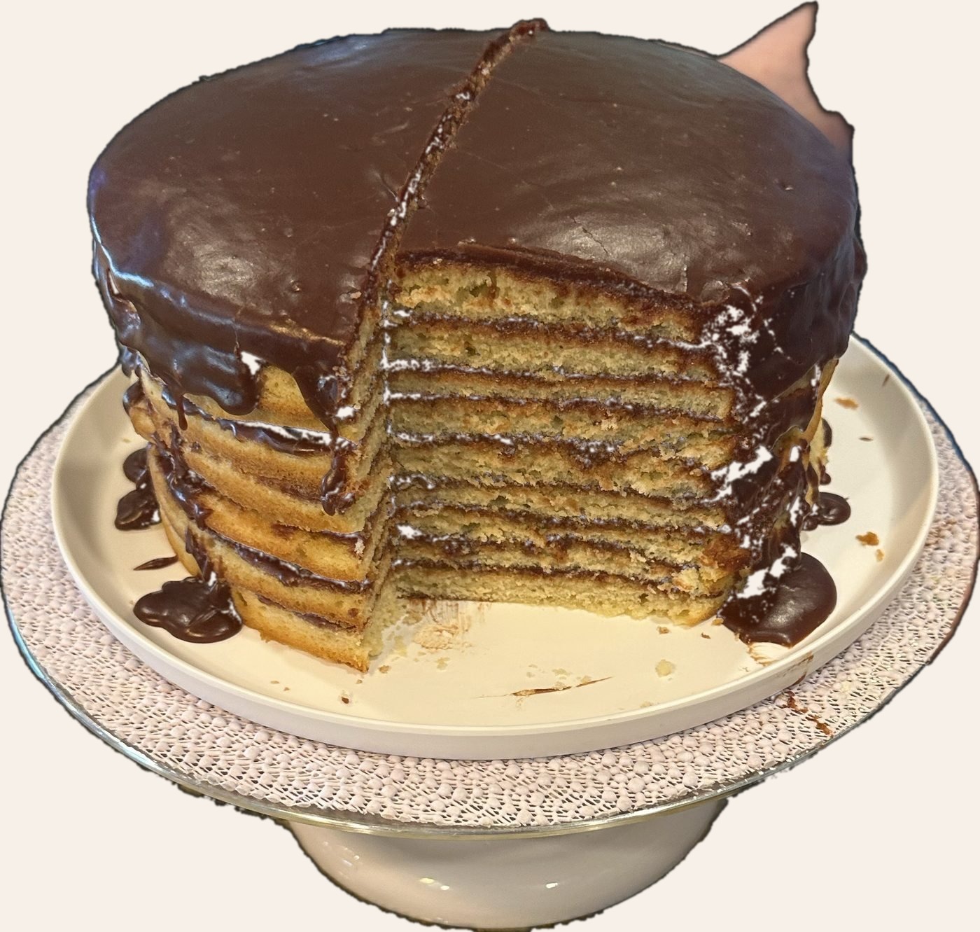 Tall multi-layer yellow honey cake with chocolate ganache filling and chocolate drip