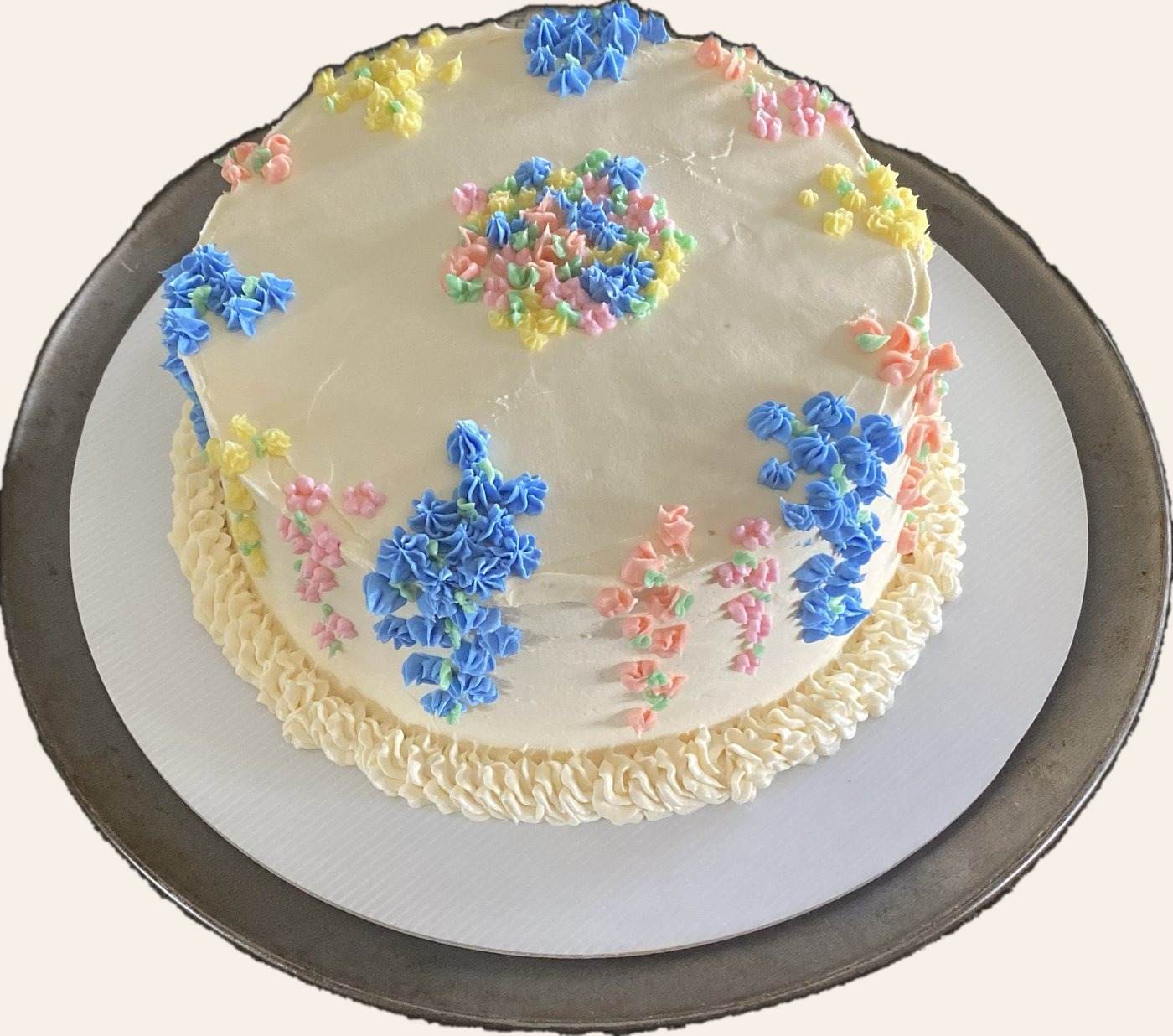 Cream cake decorated with soft pastel floral vines and piped flowers